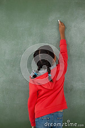 Young girl writing on chalk board Editorial Stock Photo