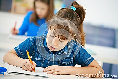 Young girl writing at school Stock Photo