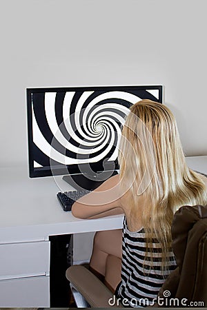 Young girlis looking at hypnosis spiral on her computer. Stock Photo