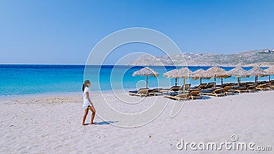 young girlon the beach of Mykonos, Elia beach Mikonos, Mykonos beach during summer with umbrella and luxury beach chairs Stock Photo