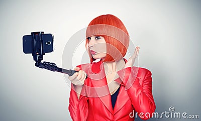 Young glamor girl in red making selfie with a stick Stock Photo