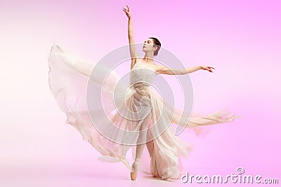 Ballerina. Young graceful female ballet dancer dancing over pink studio. Beauty of classic ballet. Stock Photo