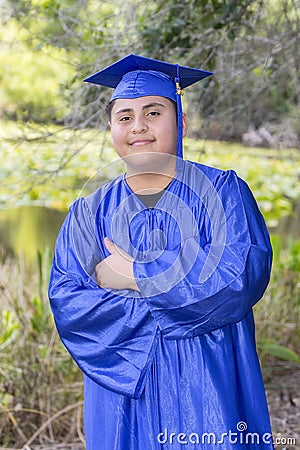 Young Graduate Posing With Cap And Gown With Thumb`s Up Stock Photo