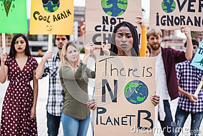 Young group of demonstrators on road from different culture and race fight for climate change - Focus on african woman Stock Photo