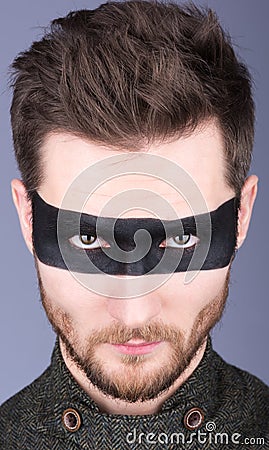 A young guy with a beard and a mustache with glasses. The black strip on the eyes. Closeup portrait Stock Photo