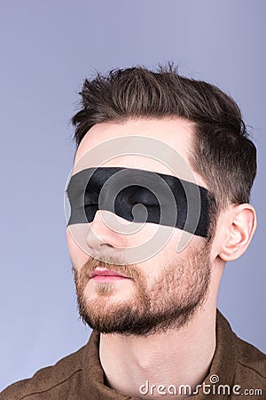 A young guy with a beard and a mustache with glasses. The black strip on the eyes. Eyes closed Stock Photo