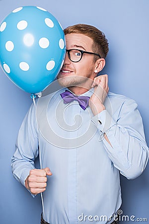 Young guy with a colorful balloon in his hand. Party, birthday, Valentine Stock Photo