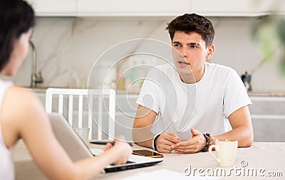 Young guy discussing deal with saleswoman in kitchen Stock Photo