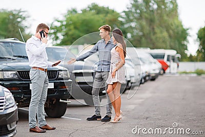 A young couple is choosing a used car. Used car theme. Stock Photo