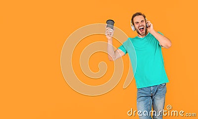 young guy in headphones drink coffee. music lover. listen to music. wireless device accessory. Stock Photo