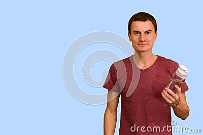 A young guy holds a bottle of water in his hand Stock Photo