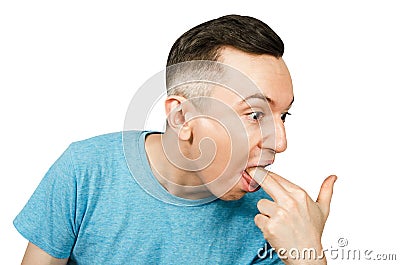Young guy inserts two fingers in the mouth to induce vomiting, on a isolated white background Stock Photo