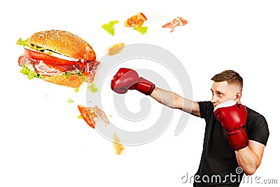 A young guy kick hamburger . The concept is the fight against unhealthy fast food Stock Photo