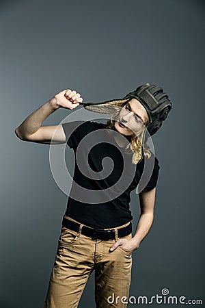 Young guy model posing in a tankman helmet on the gray background Stock Photo