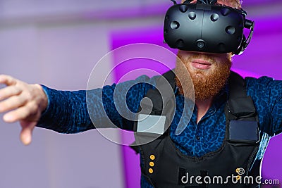 A young guy, with a red beard, is playing virtual reality games Stock Photo