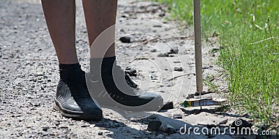 Young guys are engaged in garbage collection on the city beach. Cleaning on the lake in the hot summer. Cleaning is done with a st Editorial Stock Photo