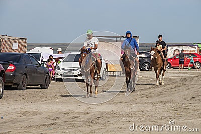 Young guys ride horses along the shore of Lake Shalkar in the West Kazakhstan region Editorial Stock Photo