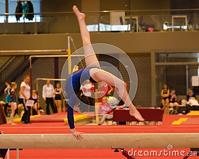 Young gymnast girl performing routine on balance beam Stock Photo