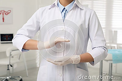 Young gynecologist holding something in clinic, closeup Stock Photo