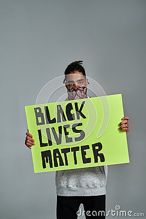 Young gypsy man holding placard with anti racism quote Editorial Stock Photo