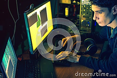 Young hacker in the dark infect computers and systems Stock Photo