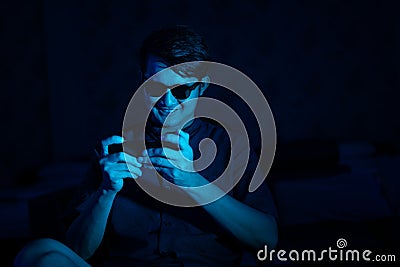 Young hacker style using mobile phone to access data Stock Photo