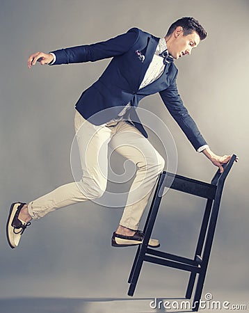 Young handsoman businessman fooling aroung with chair, modern mem Stock Photo