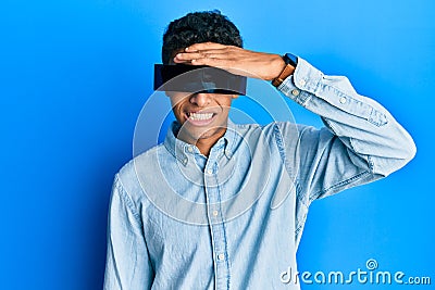 Young handsome african american man wearing banner glasses covering eyes stressed and frustrated with hand on head, surprised and Stock Photo
