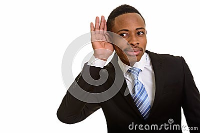 Young handsome African businessman listening and cupping ear Stock Photo