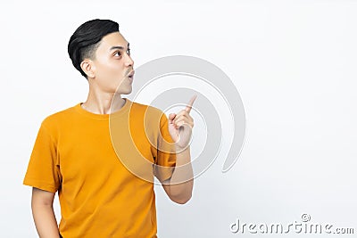 Young handsome Asian man being surprised with his finger pointing up to copyspace on white background. Stock Photo