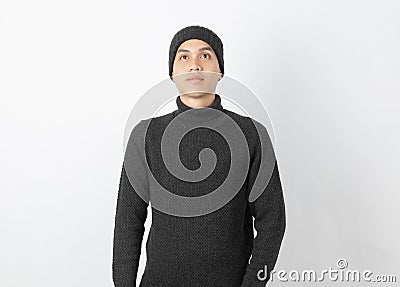 Young handsome asian man wearing grey sweater and beanie thinking an idea while looking up on white background. Stock Photo