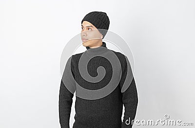 Young handsome asian man wearing grey sweater and beanie thinking an idea while looking up on white background. Stock Photo