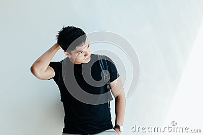 Young handsome asian men wearing casual plain black Tshirt and backpack at day in Sai Gon city, Vietnam Stock Photo