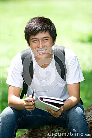 Young handsome Asian student with laptop Stock Photo