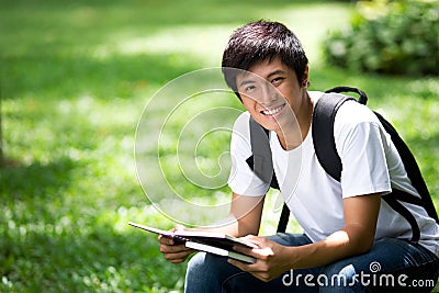 Young handsome Asian student with laptop Stock Photo