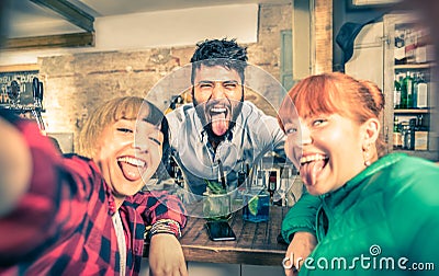 Young handsome bartender flirting with beautiful girls at bar Stock Photo