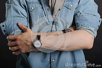 Young handsome boy in denim shirt and glases, black clock on hand Stock Photo