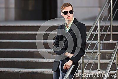 Young handsome business man in black blazer and sunglasses Stock Photo