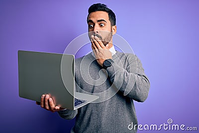 Young handsome businessman with beard working using laptop over purple background cover mouth with hand shocked with shame for Stock Photo