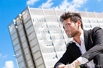 Young and handsome businessman sitting thinking Stock Photo