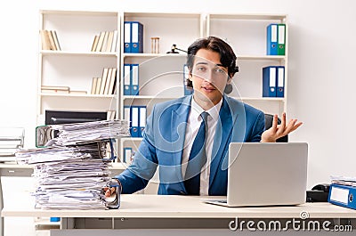 The young handsome busy employee sitting in office Stock Photo