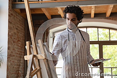 Young handsome painter man painting pictures on canvas Stock Photo