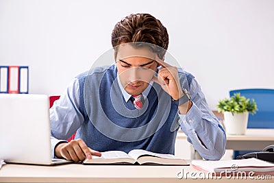 The young handsome employee working in the office Stock Photo