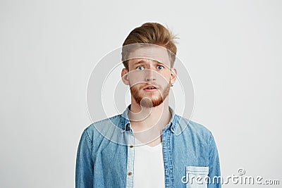 Young handsome guy looking at camera naively hopefully over white background. Stock Photo