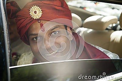 Young handsome Hindu groom looking out the window Stock Photo