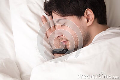 Young handsome man is asleep and wristband tracking his sleep Stock Photo