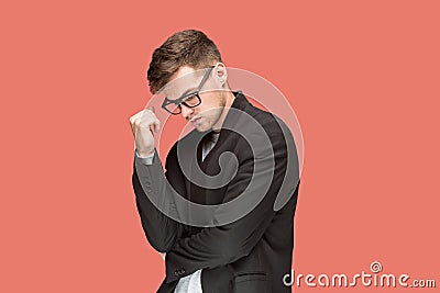 Young handsome man in black suit and glasses isolated on red background Stock Photo