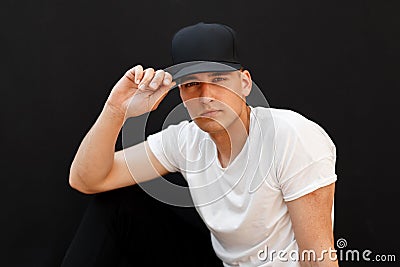 Young handsome man in a fashionable black cap and white T-shirt Stock Photo