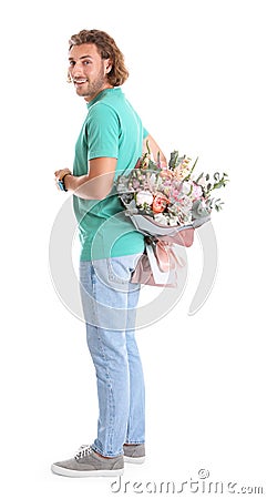 Young handsome man hiding beautiful flower bouquet behind his back Stock Photo