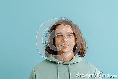 Young handsome man with long hair in hoodie looking Stock Photo